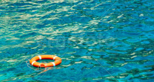 Red life buoy with a white cross strips